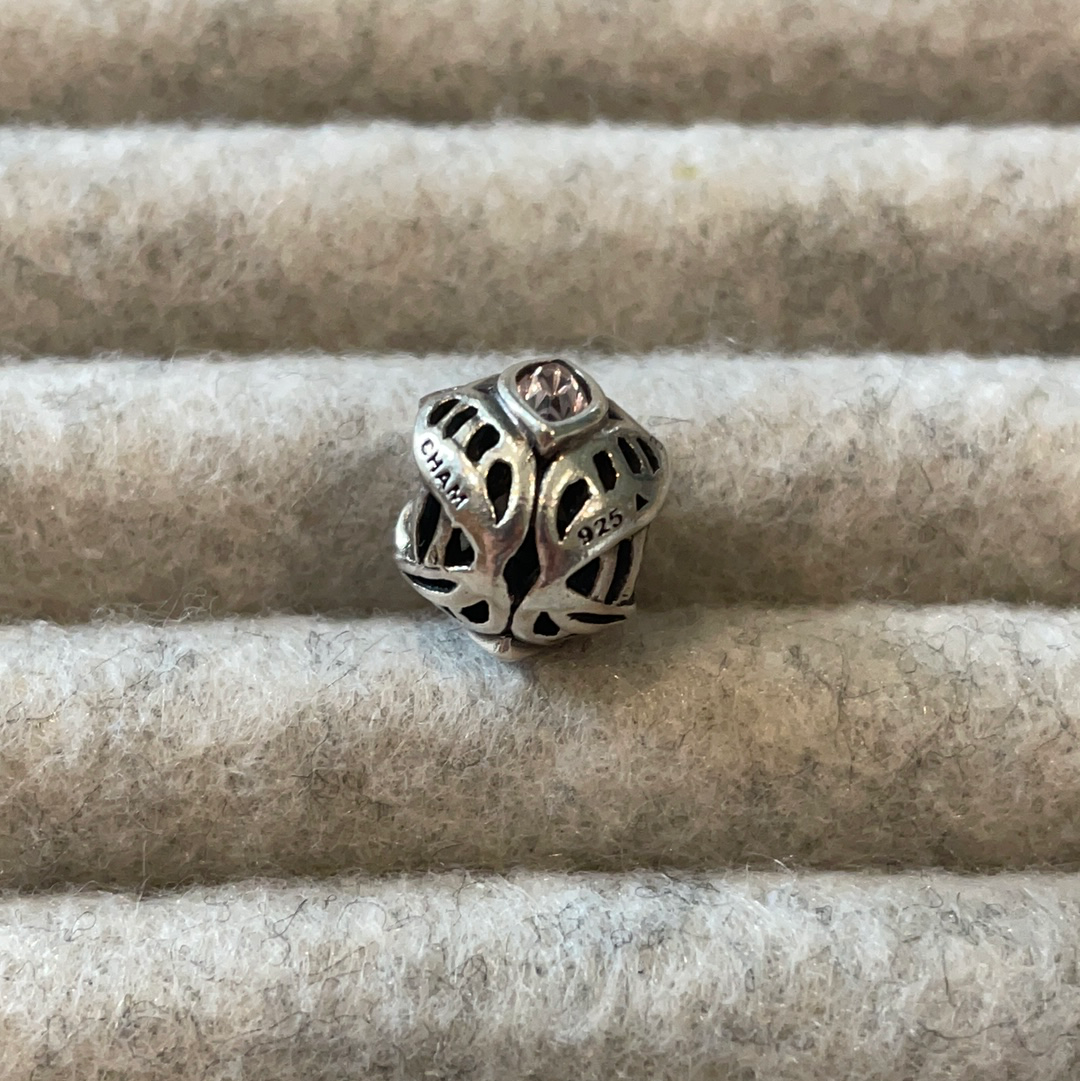 Genuine Chamilia open work charm with purple stone
